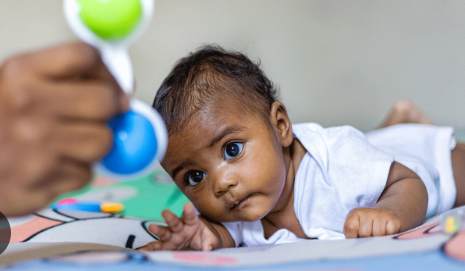 Baby engaged in active tummy time exploring on play mat
